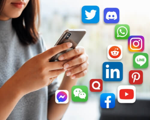 A person scrolling on a smartphone surrounded by social media app icons representing regional language social media marketing for Indian brands 